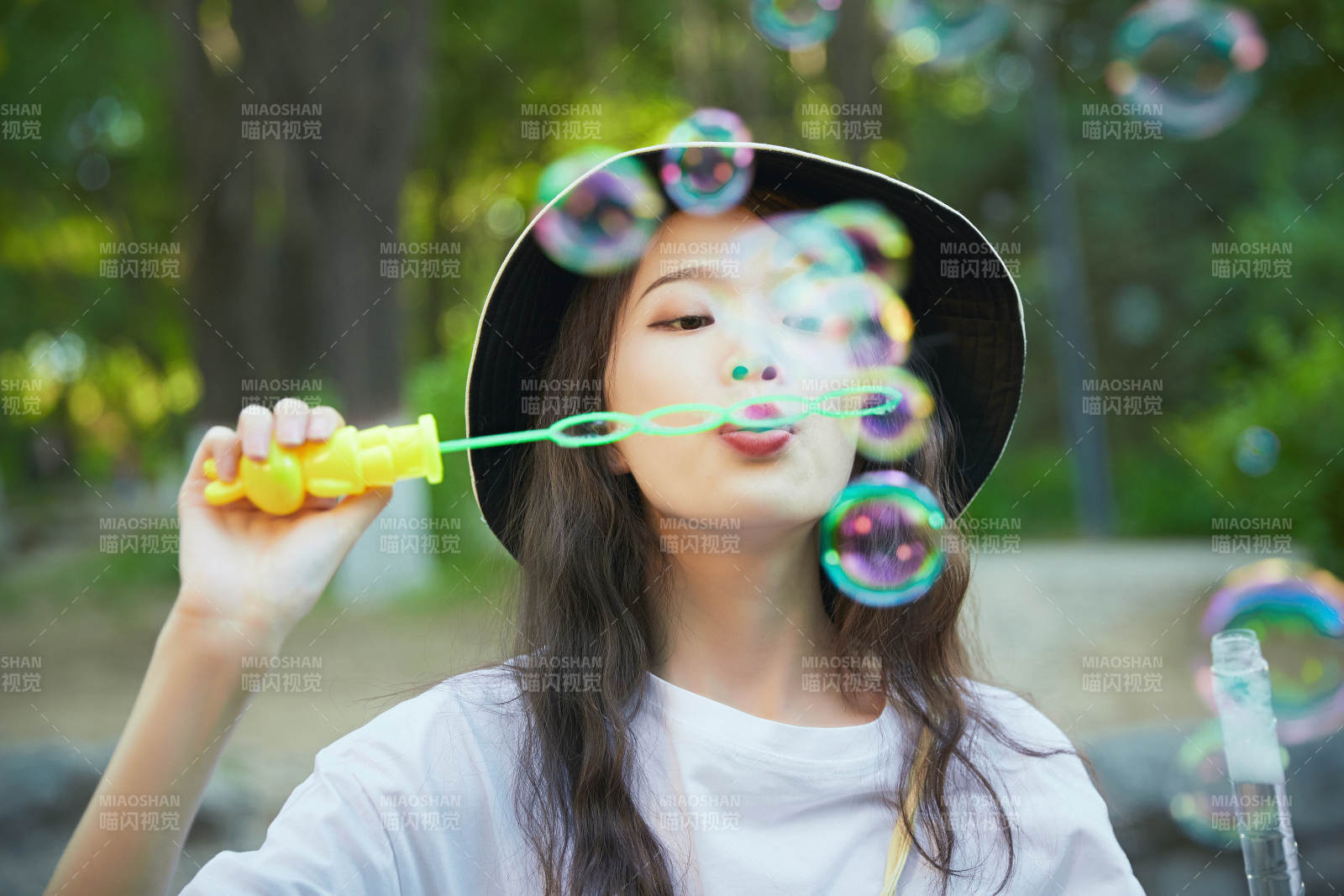 戶外公園里玩吹泡泡的可愛亞洲少女