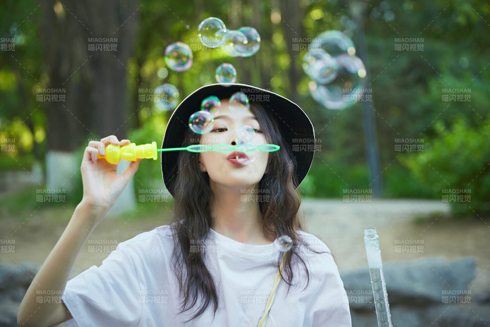 戶外公園里玩吹泡泡的可愛亞洲少女
