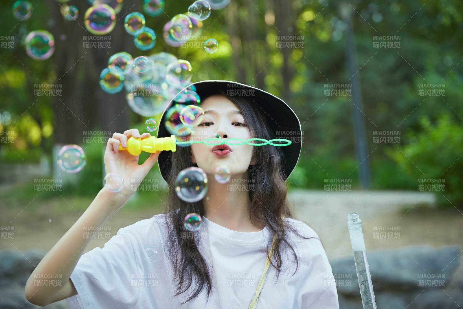 戶外公園里玩吹泡泡的可愛亞洲少女