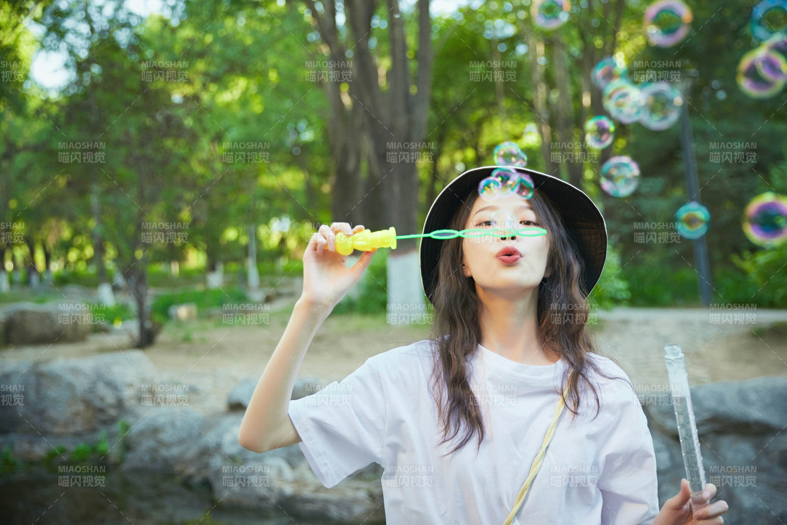 戶外公園里玩吹泡泡的可愛亞洲少女