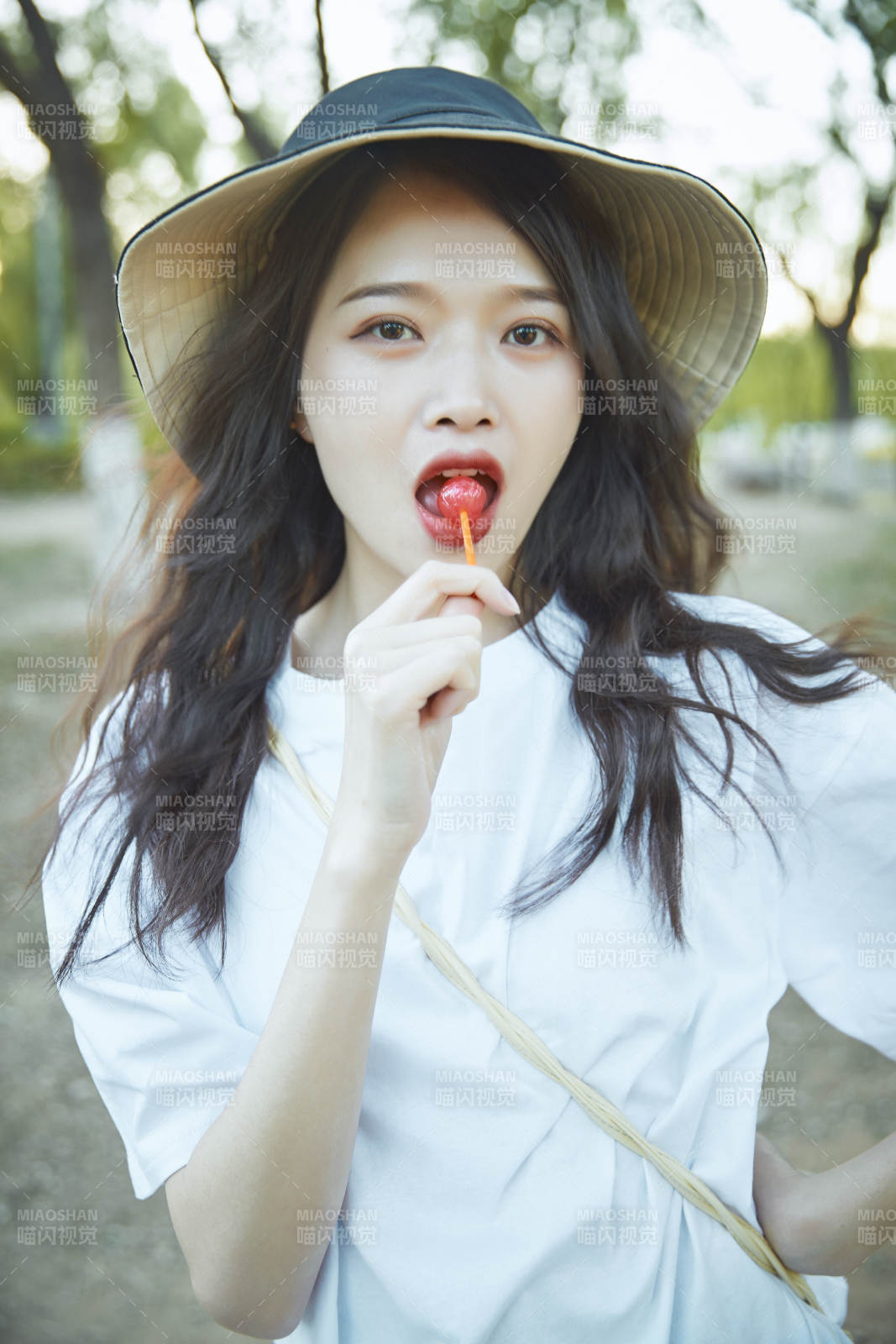 公園湖邊吃棒棒糖的亞洲可愛少女