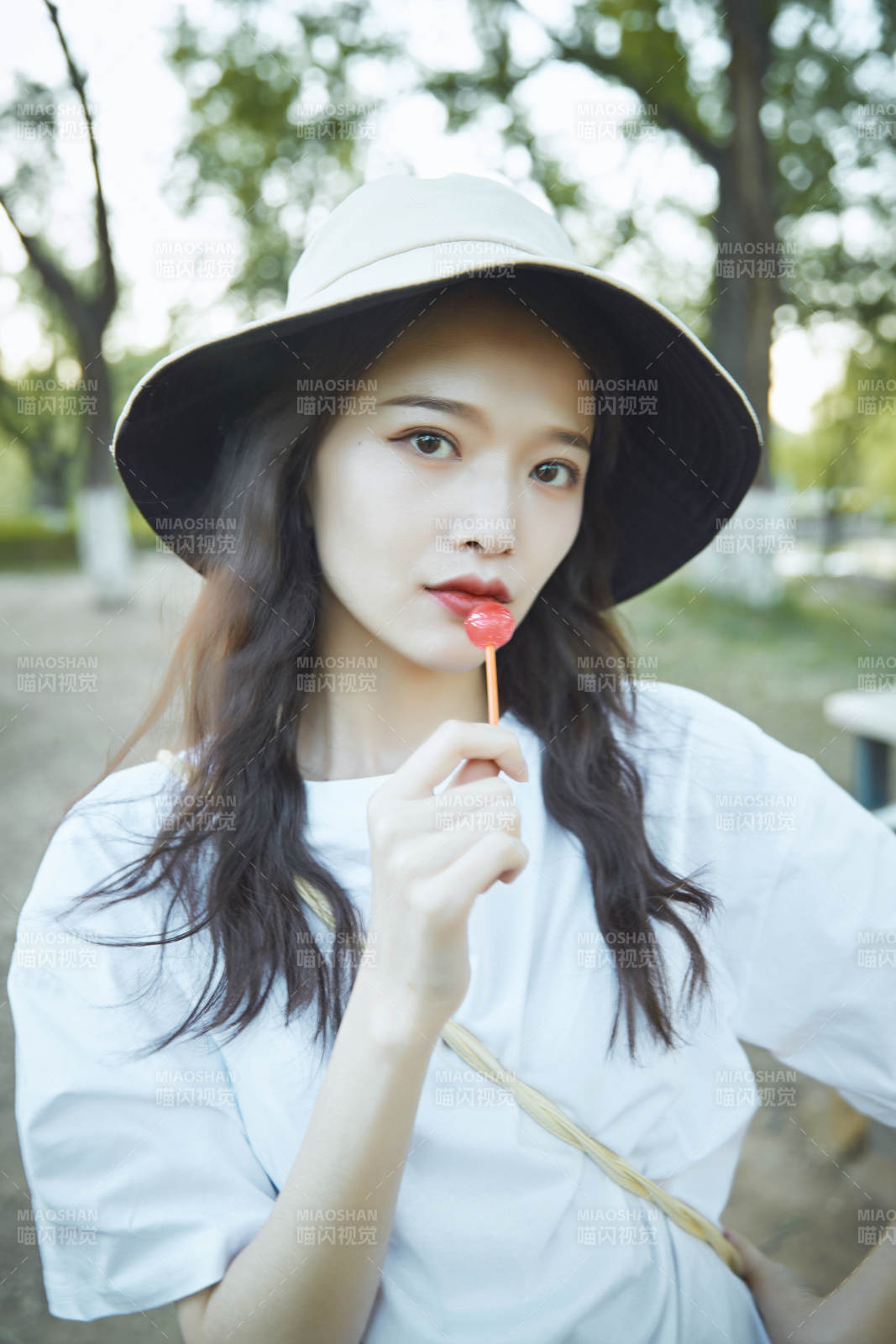 公園湖邊吃棒棒糖的亞洲可愛少女