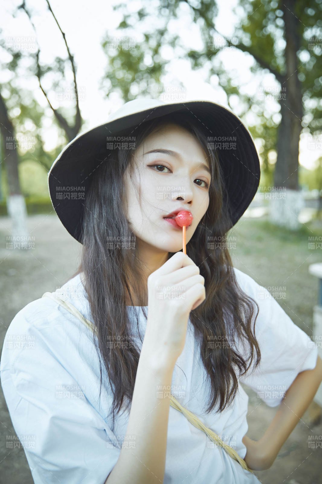 公園湖邊吃棒棒糖的亞洲可愛少女