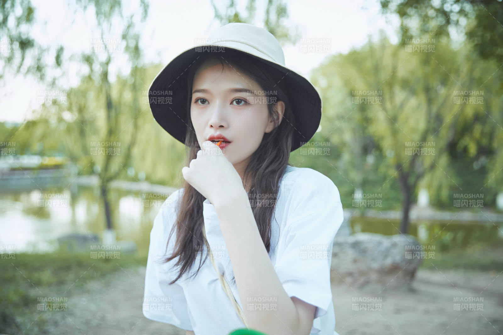 公園湖邊吃棒棒糖的亞洲可愛少女