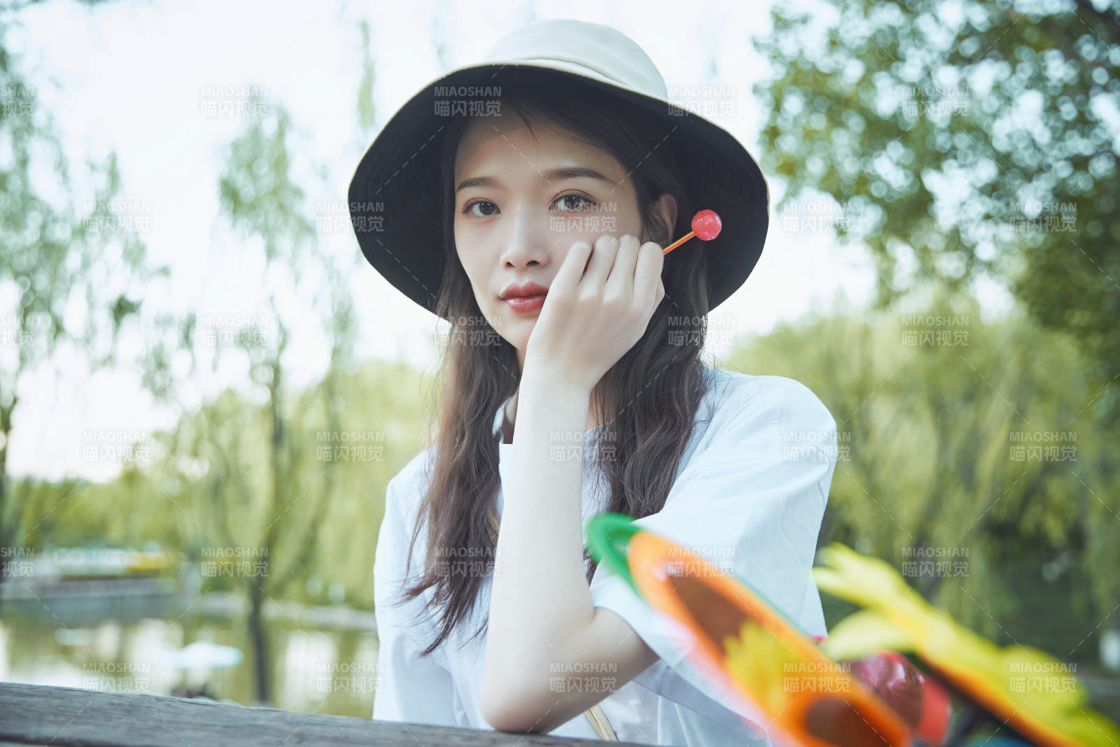 公園湖邊吃棒棒糖的亞洲可愛少女