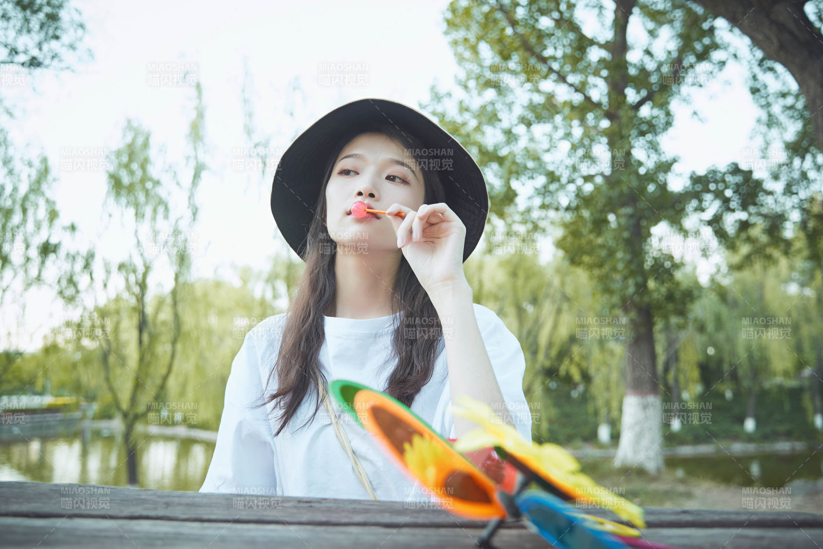 公園湖邊吃棒棒糖的亞洲可愛少女