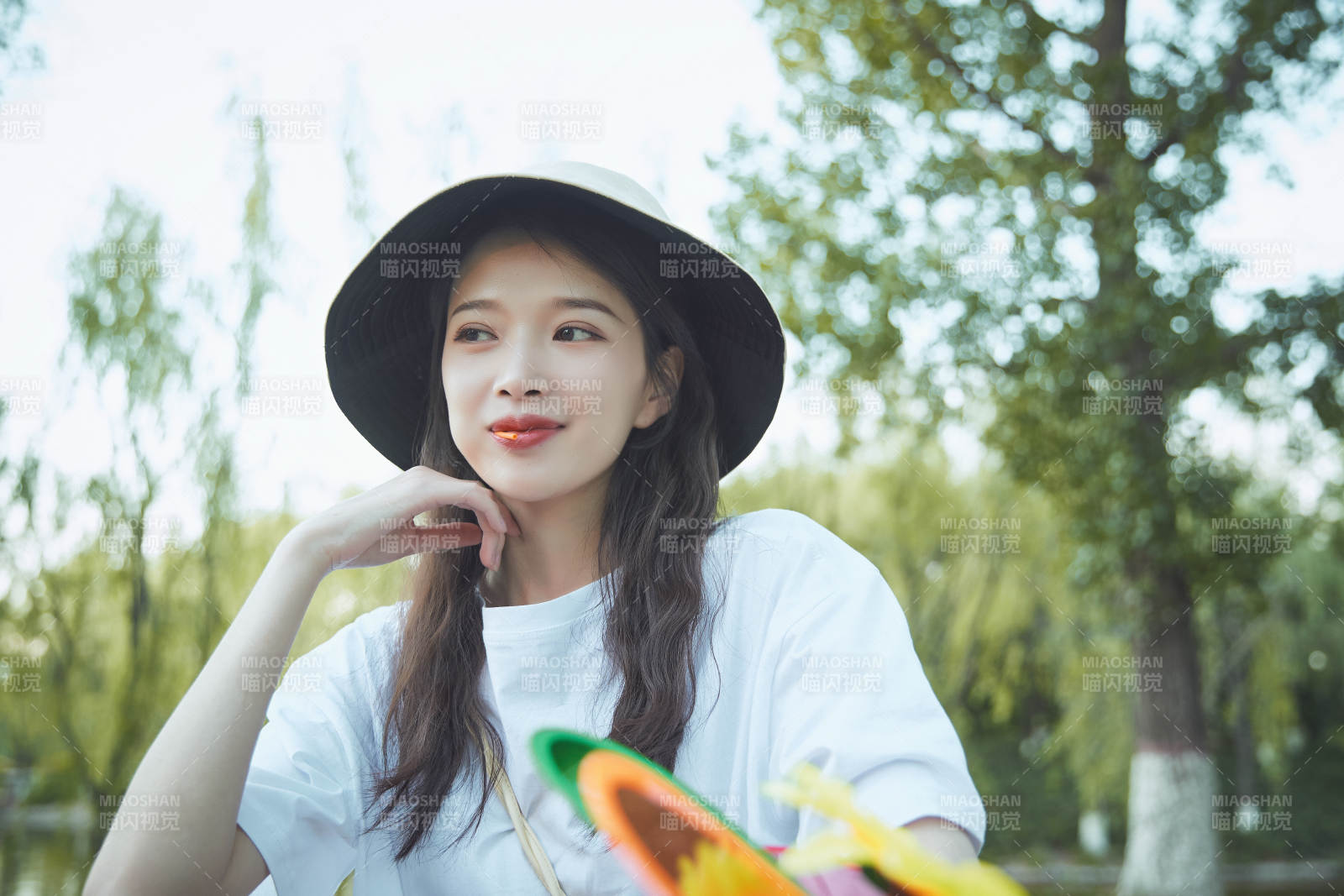 公園湖邊吃棒棒糖的亞洲可愛少女