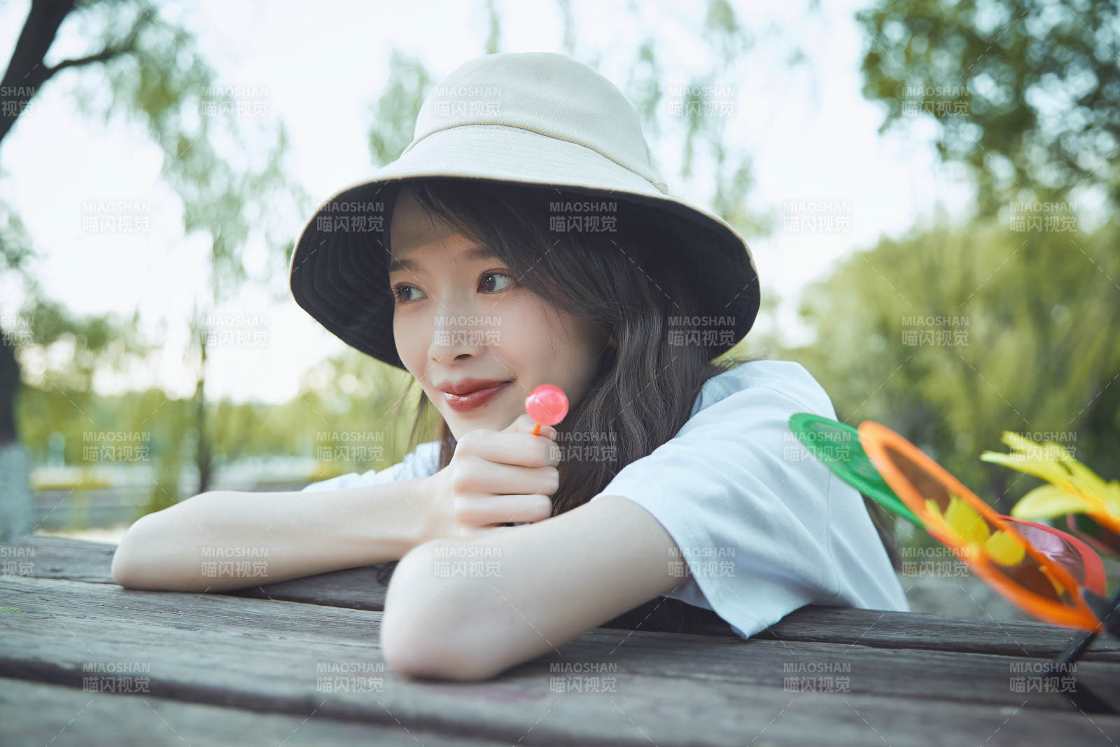 公園湖邊吃棒棒糖的亞洲可愛少女