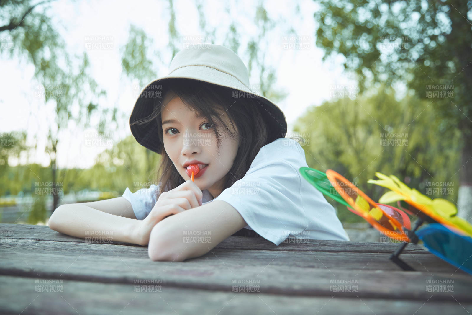 公園湖邊吃棒棒糖的亞洲可愛少女