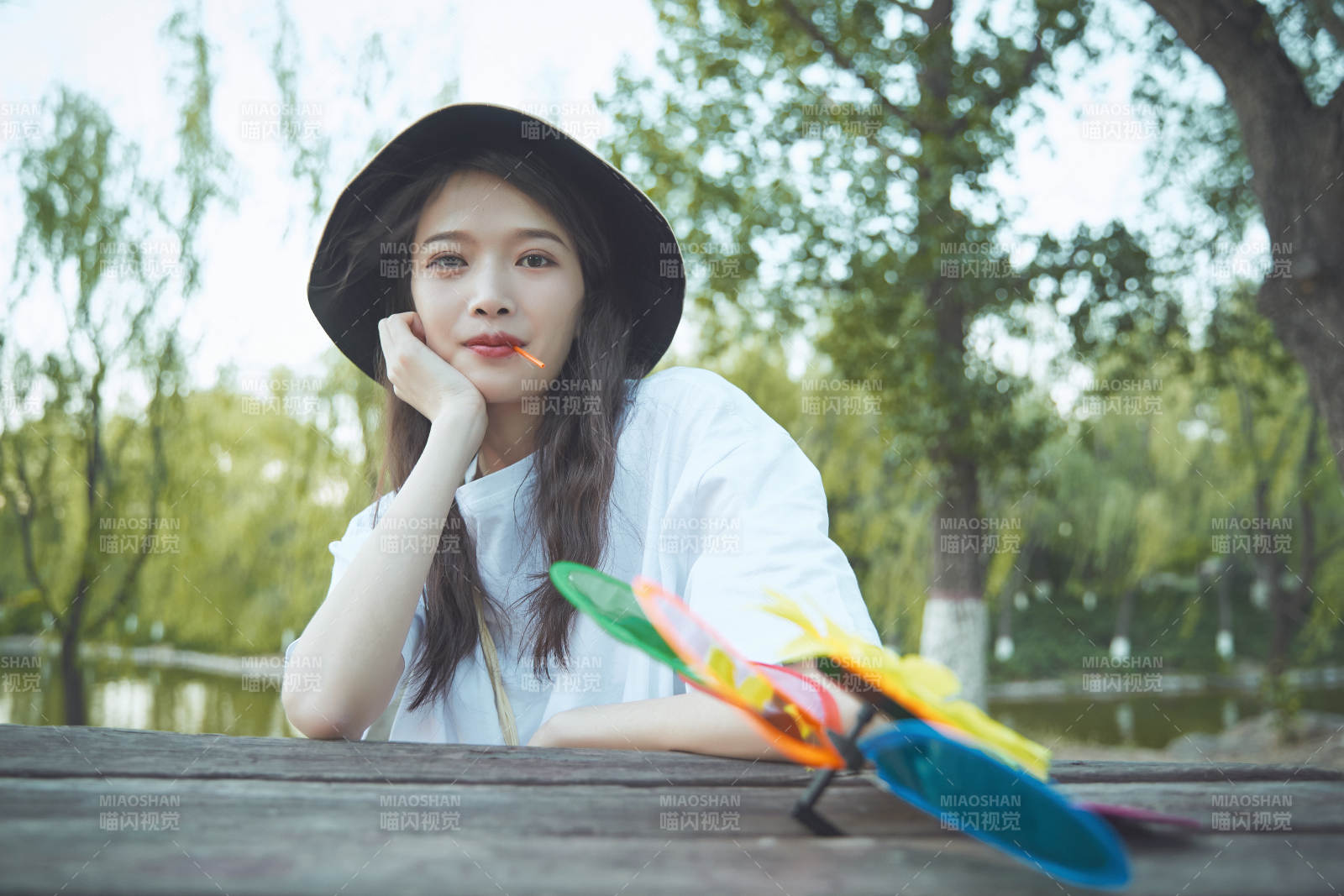 公園湖邊吃棒棒糖的亞洲可愛少女