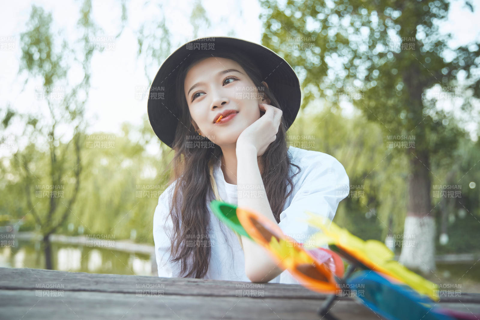 公園湖邊吃棒棒糖的亞洲可愛少女