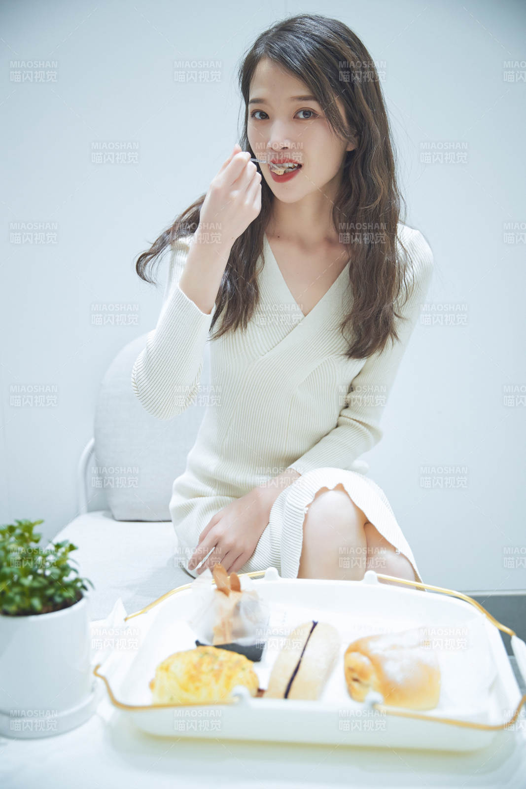 在烘焙店吃面包喝牛奶的可愛亞洲少女