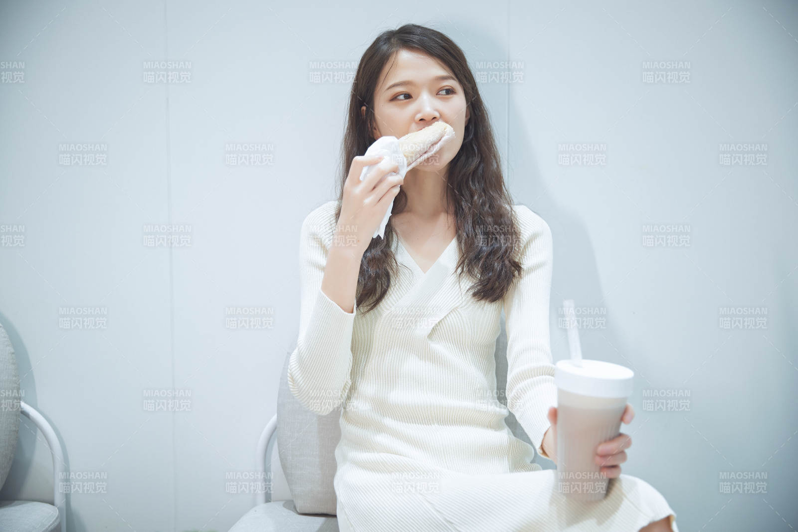 在烘焙店吃面包喝牛奶的可愛亞洲少女