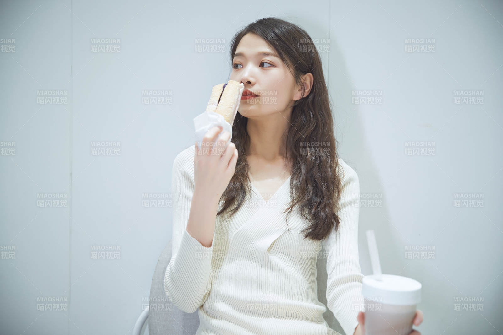 在烘焙店吃面包喝牛奶的可愛亞洲少女