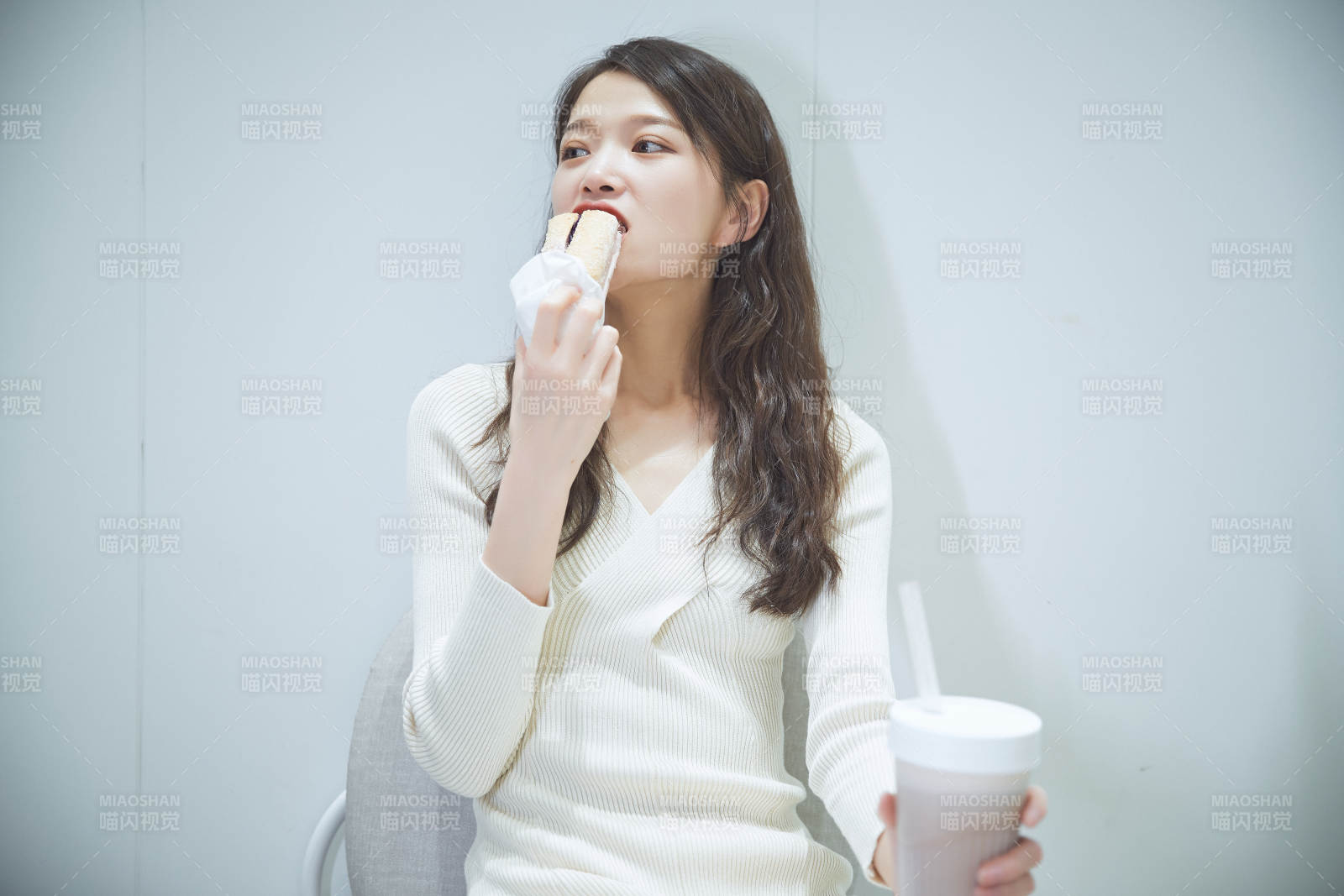 在烘焙店吃面包喝牛奶的可愛亞洲少女