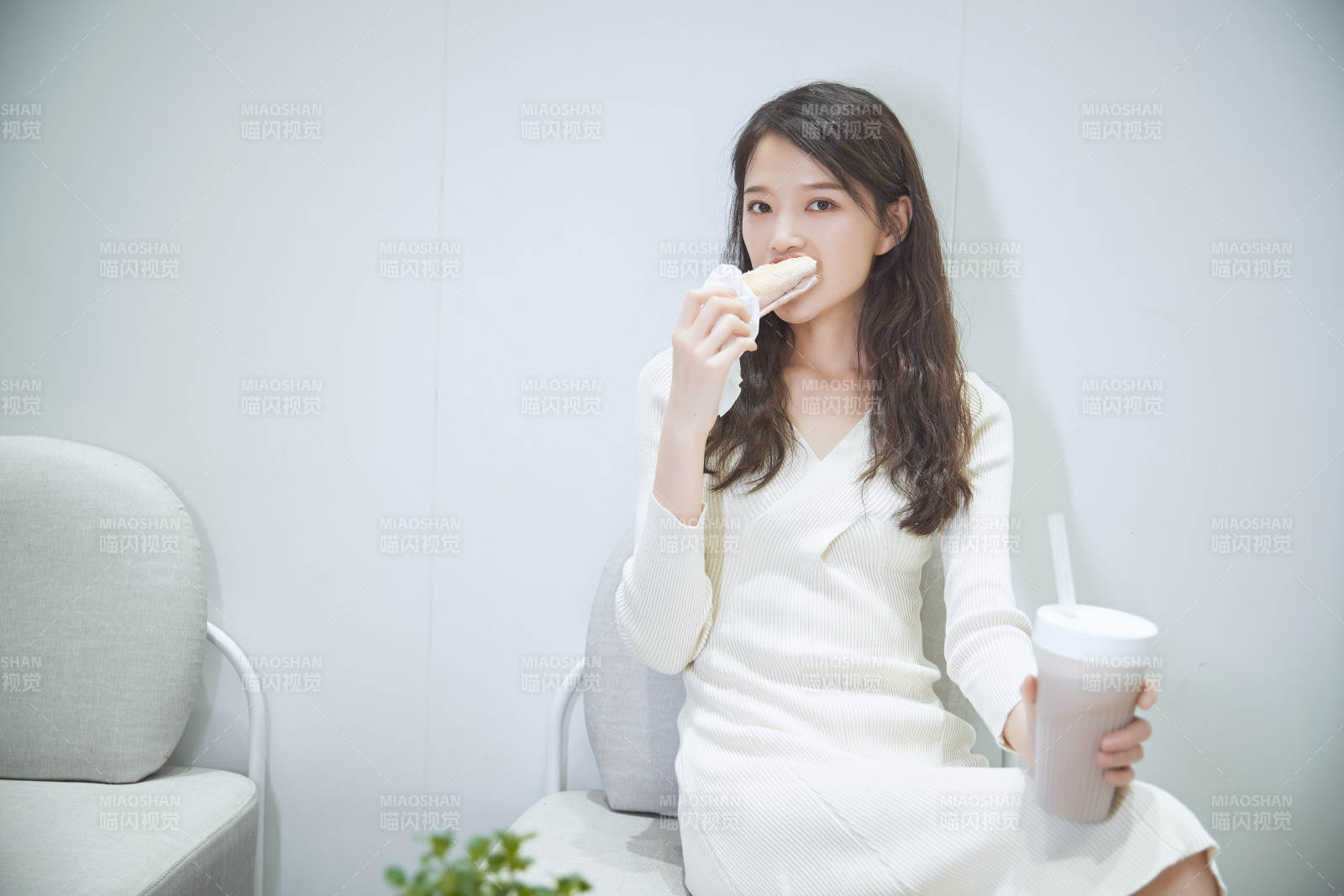 在烘焙店吃面包喝牛奶的可愛亞洲少女