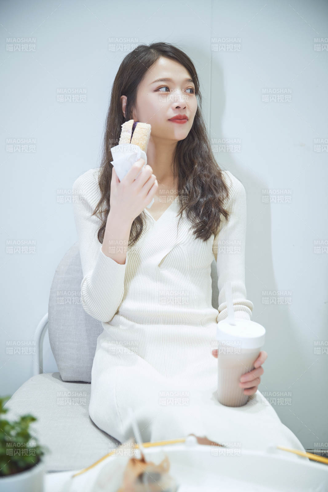 在烘焙店吃面包喝牛奶的可爱亚洲少女