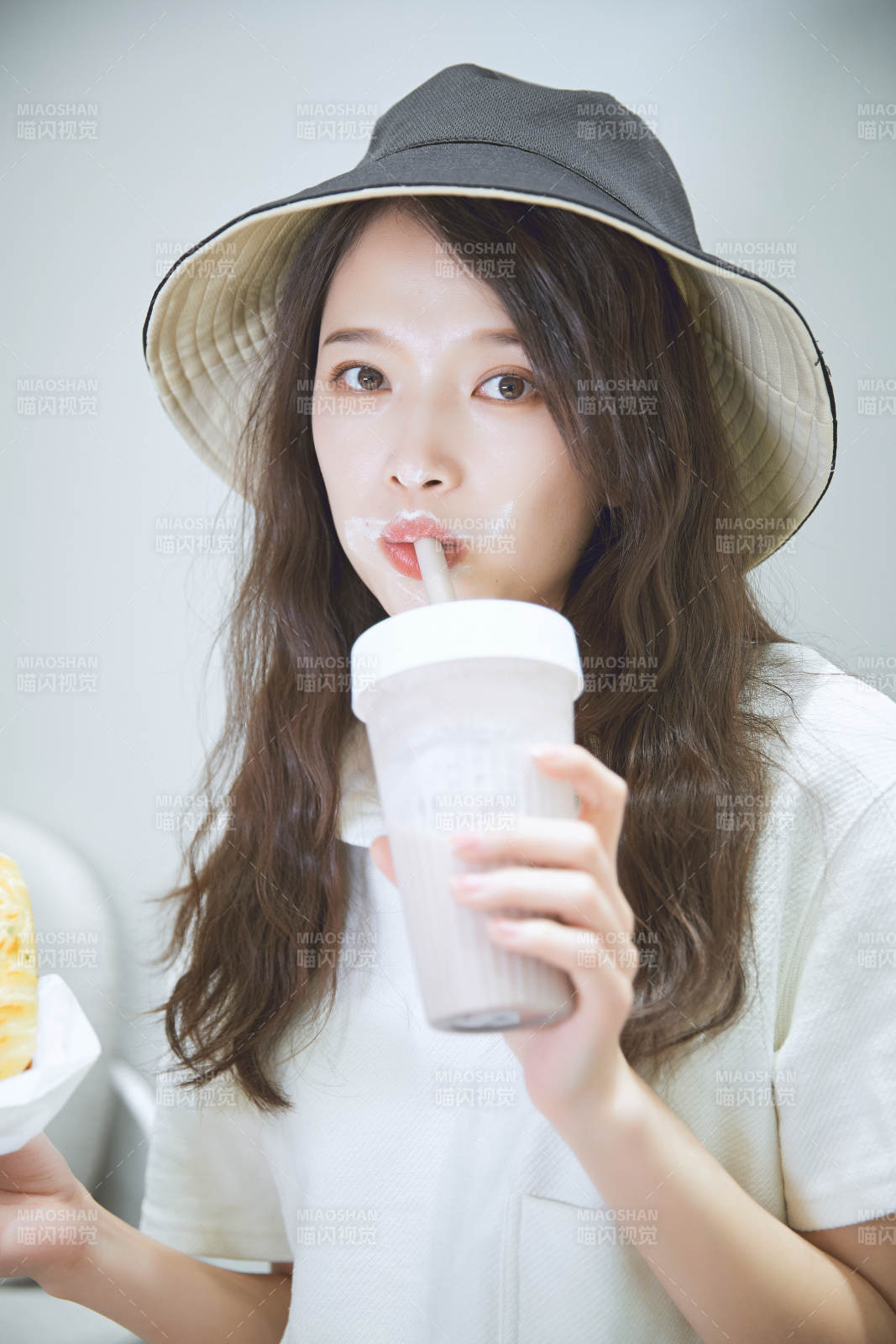 在烘焙店吃面包喝牛奶的可爱亚洲少女