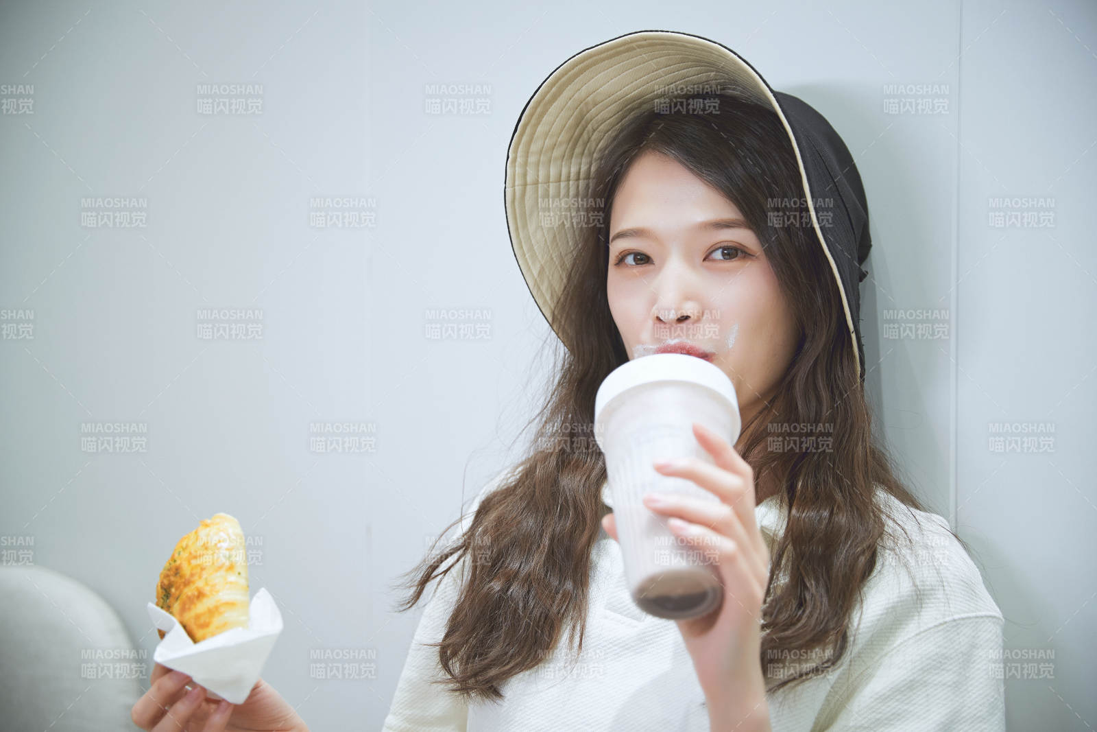 在烘焙店吃面包喝牛奶的可愛亞洲少女