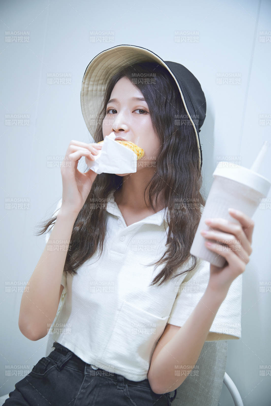 在烘焙店吃面包喝牛奶的可愛亞洲少女