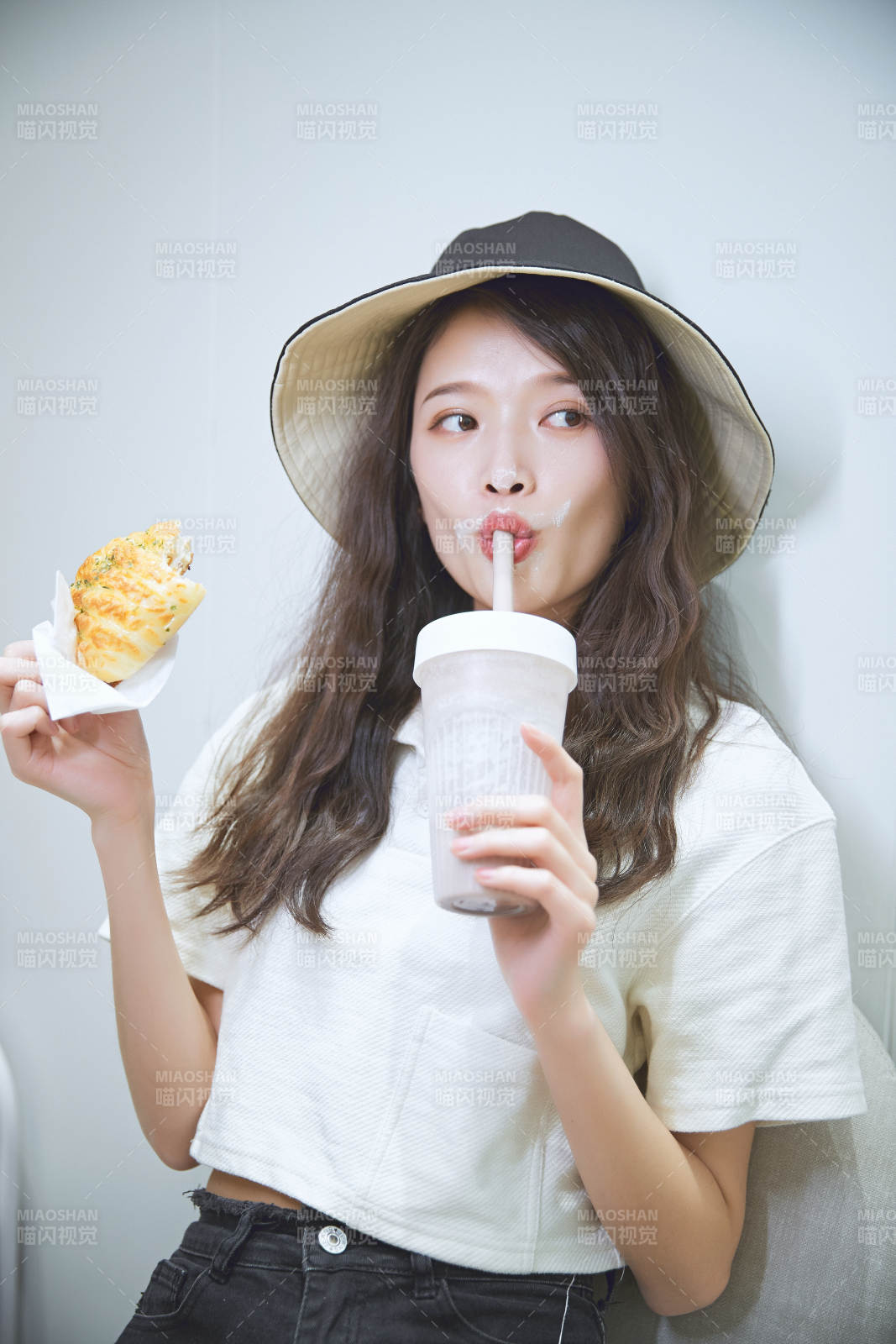 在烘焙店吃面包喝牛奶的可愛亞洲少女