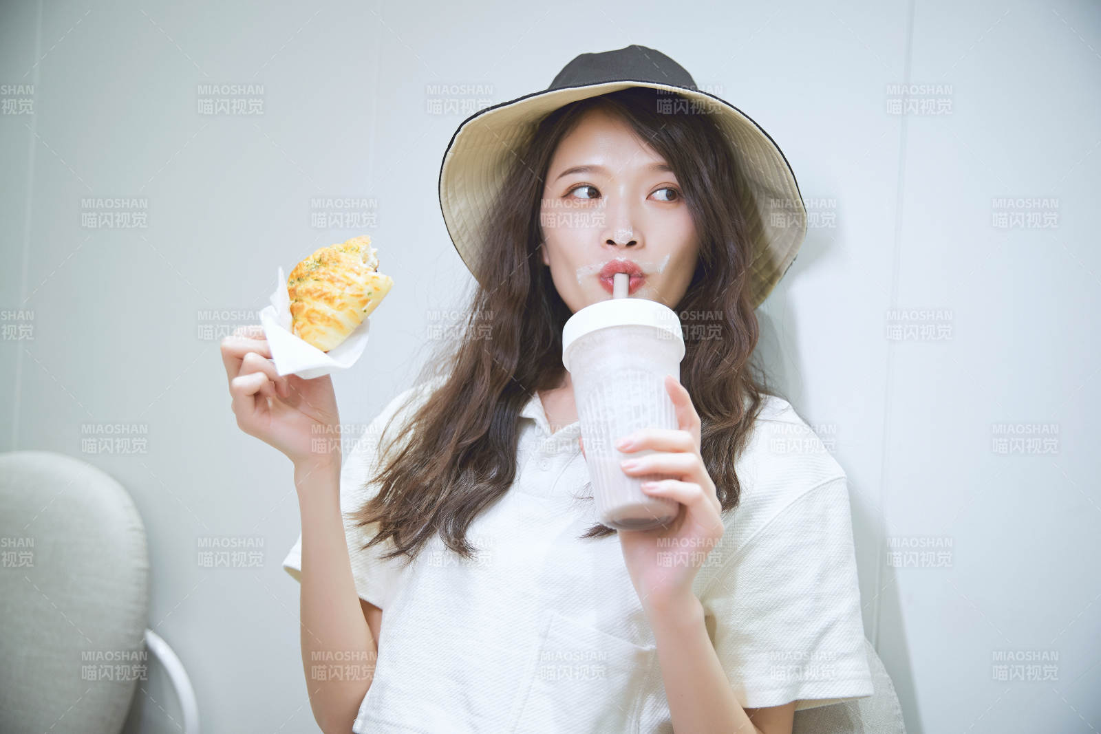 在烘焙店吃面包喝牛奶的可愛亞洲少女