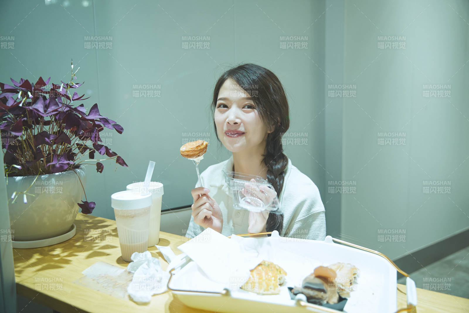 在烘焙店吃面包喝牛奶的可愛亞洲少女