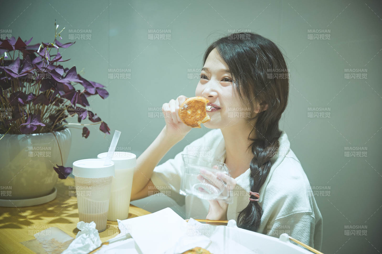 在烘焙店吃面包喝牛奶的可愛亞洲少女