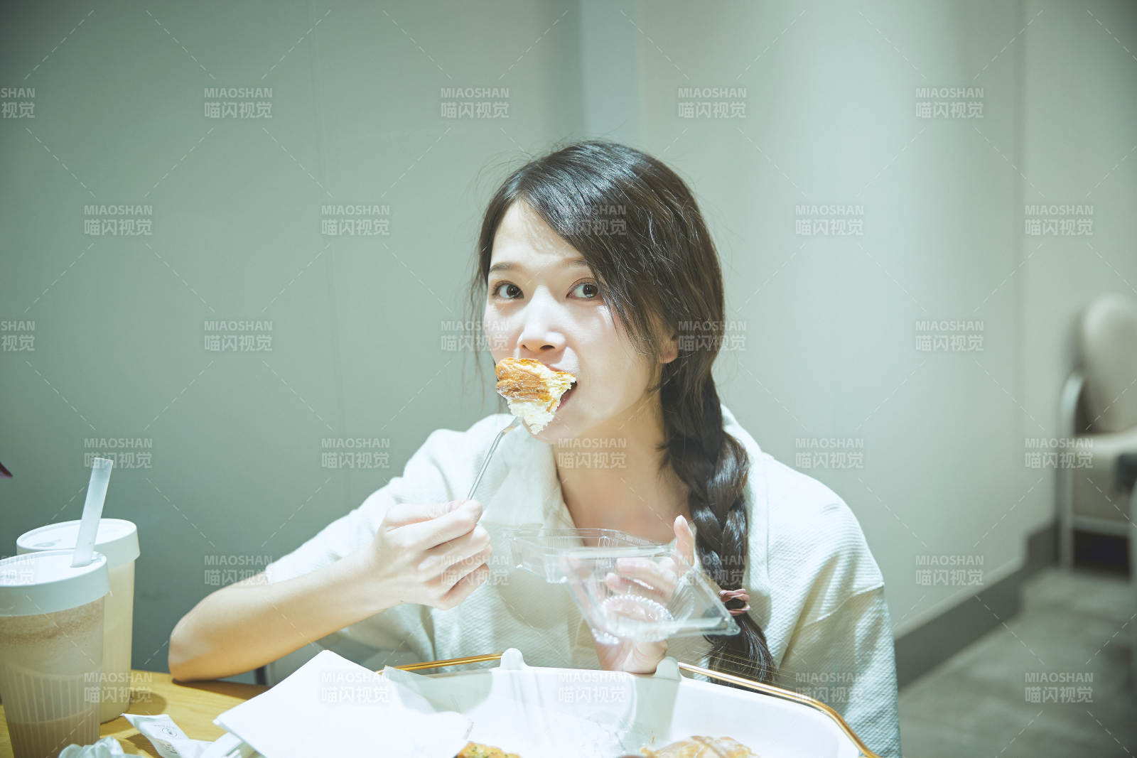 在烘焙店吃面包喝牛奶的可愛亞洲少女