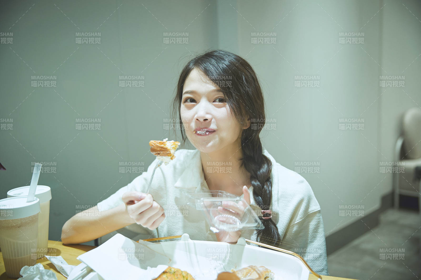 在烘焙店吃面包喝牛奶的可愛亞洲少女