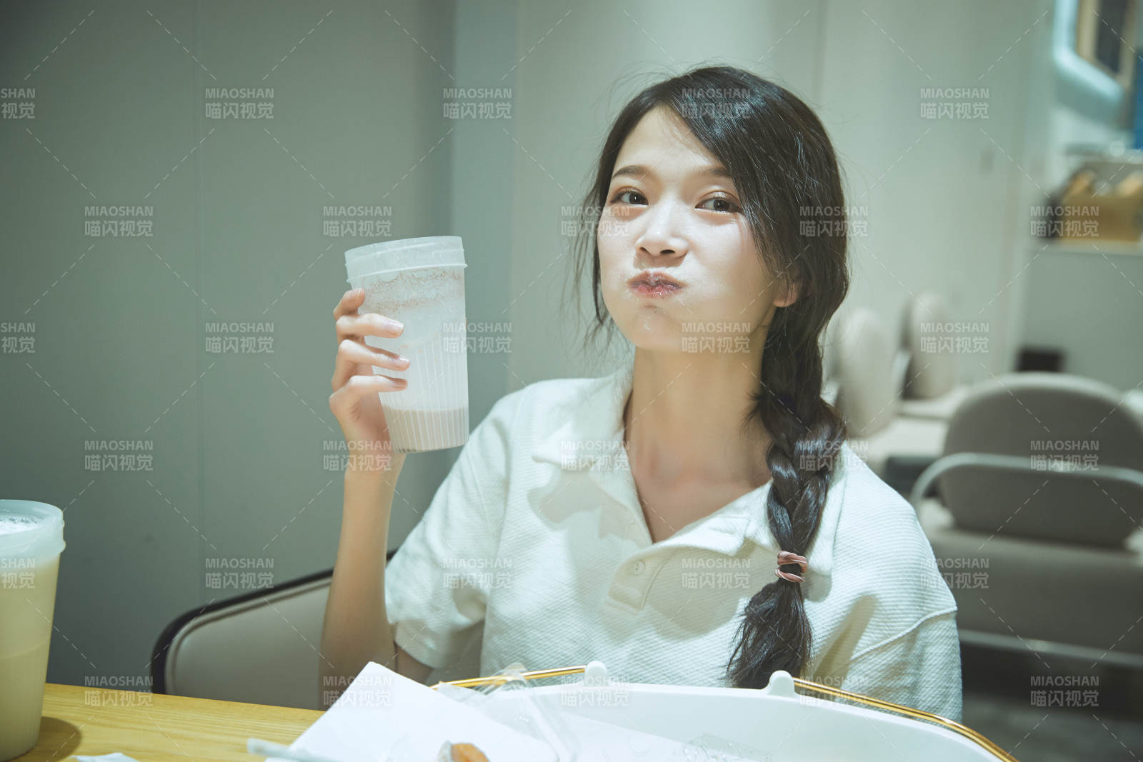 在烘焙店吃面包喝牛奶的可愛亞洲少女