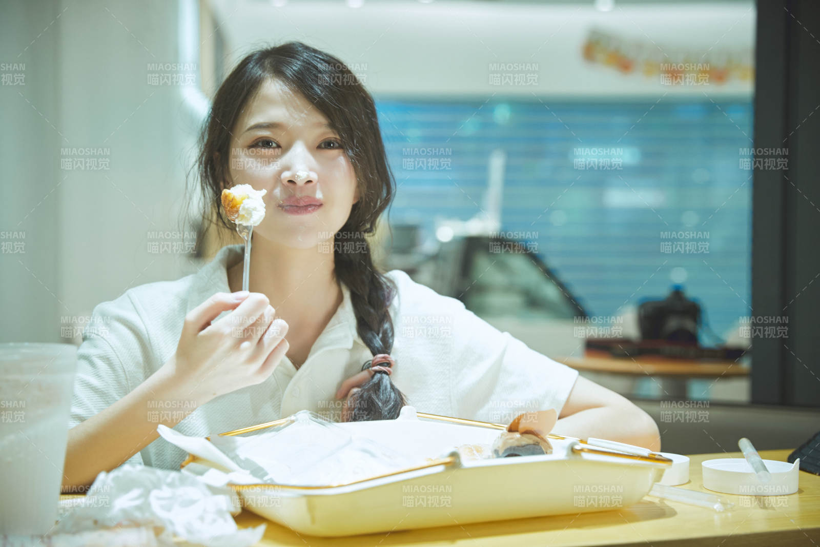 在烘焙店吃面包喝牛奶的可愛亞洲少女