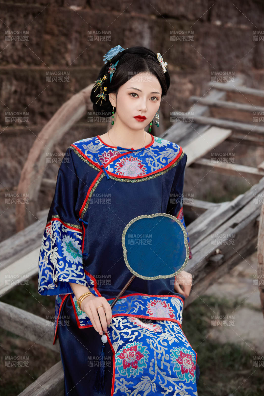 坐在古老手推車上的身穿晚清服飾的美女