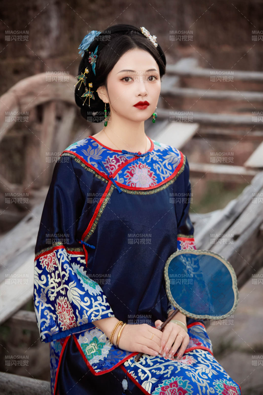 坐在古老手推車上的身穿晚清服飾的美女