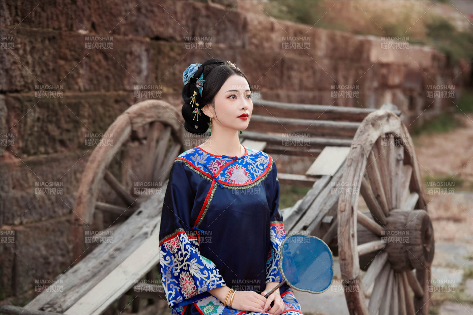 坐在古老手推車上的身穿晚清服飾的美女