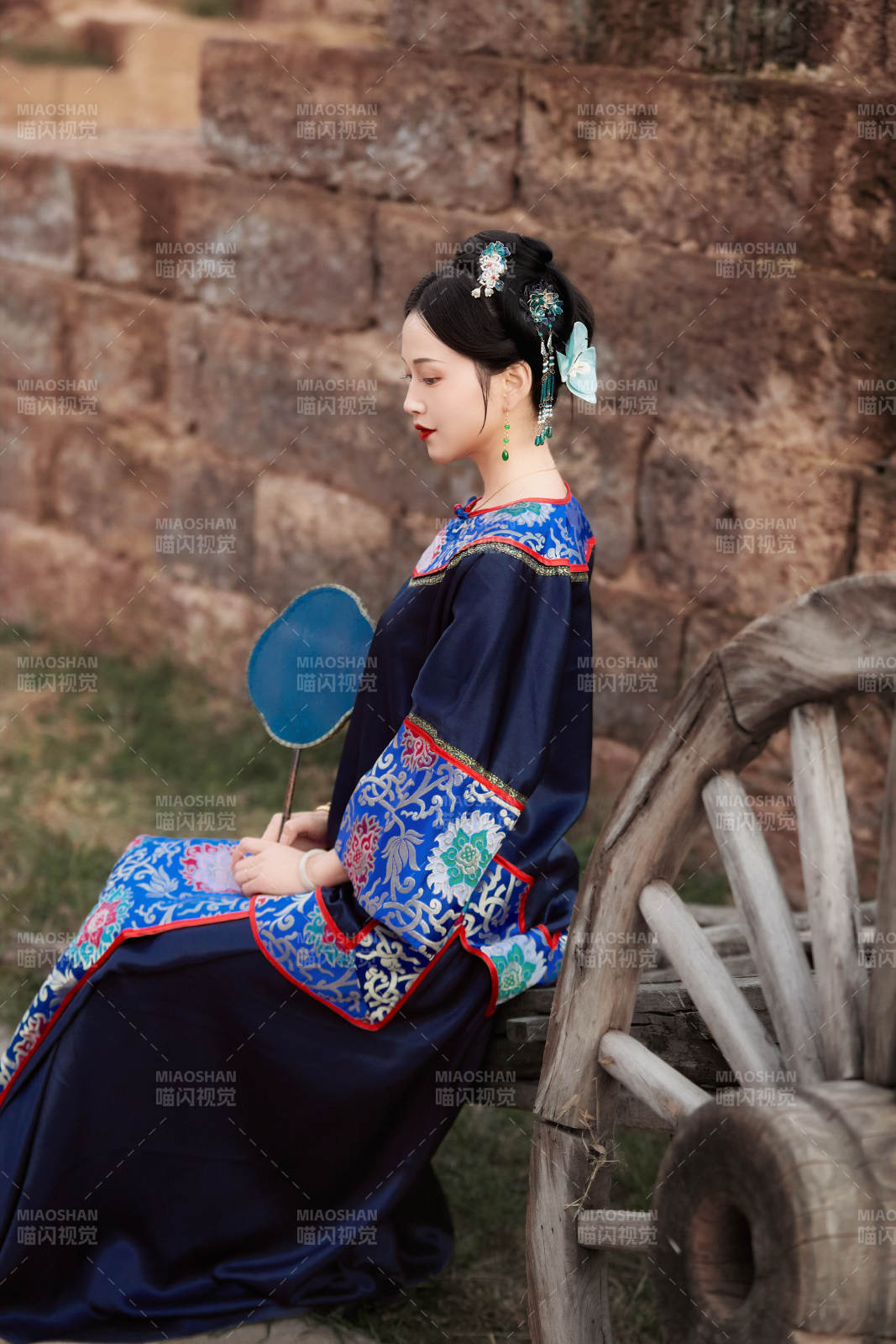 坐在古老手推車上的身穿晚清服飾的美女