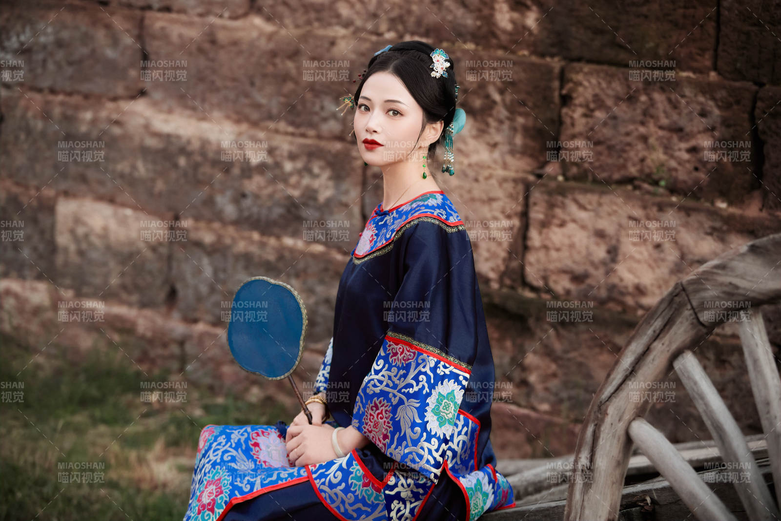 坐在古老手推車上的身穿晚清服飾的美女