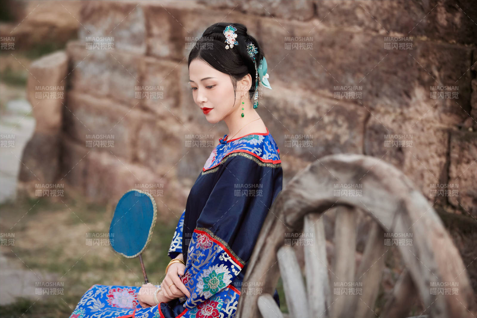 坐在古老手推車上的身穿晚清服飾的美女