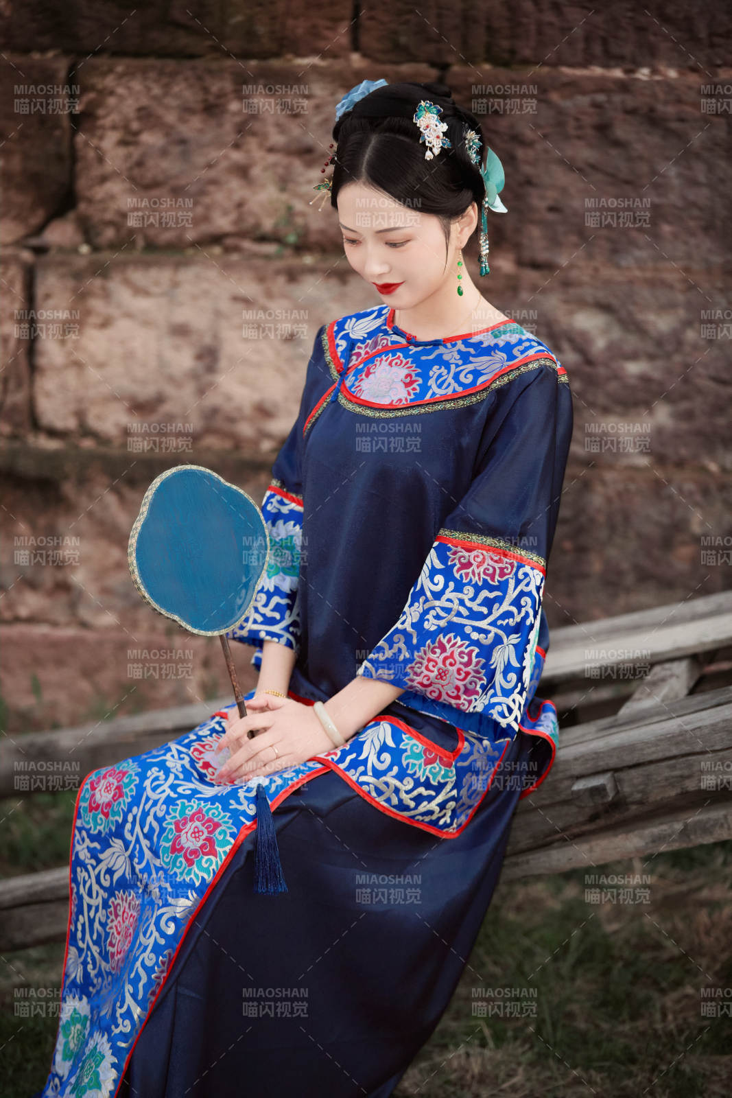 坐在古老手推車上的身穿晚清服飾的美女