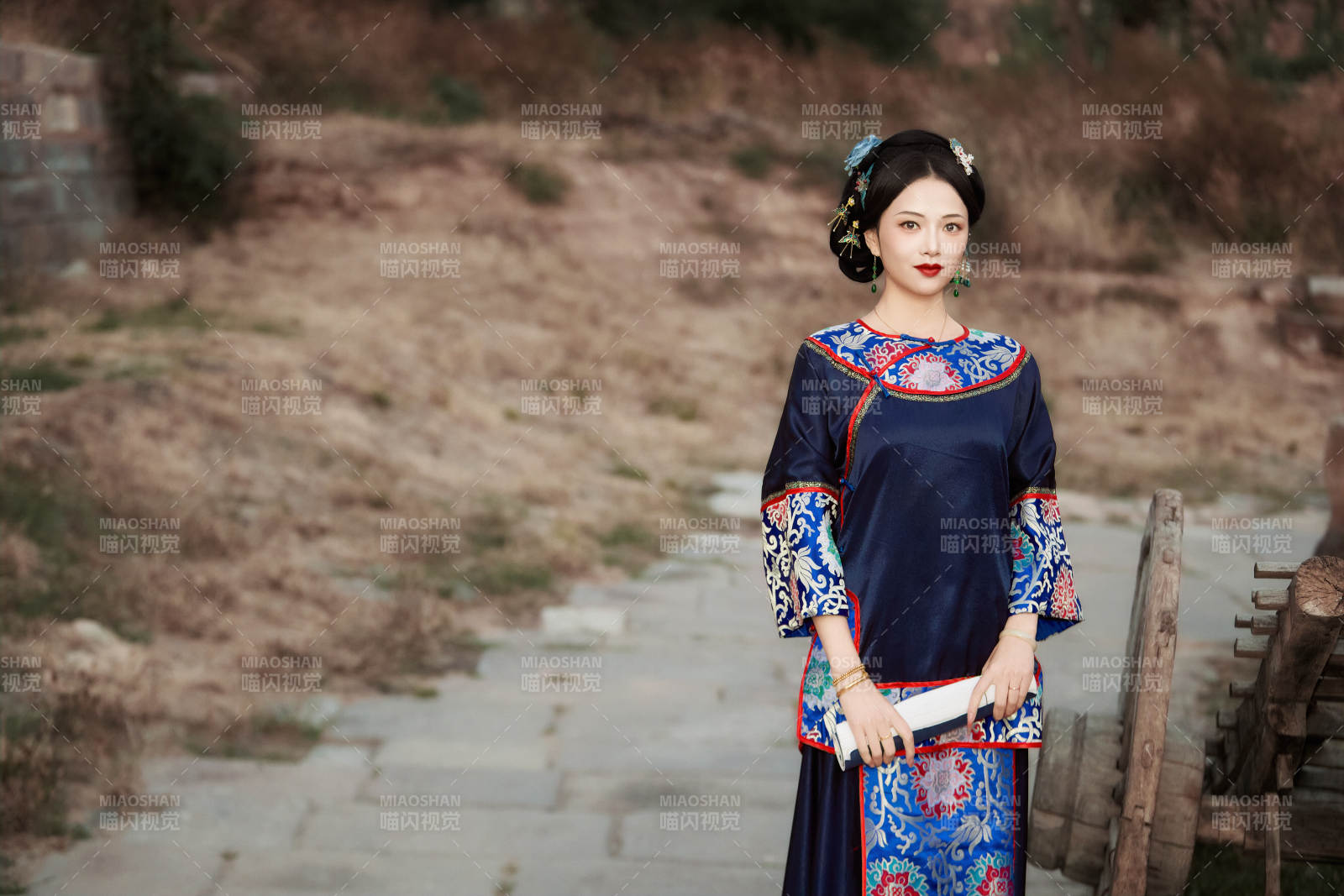 坐在古老手推車上的身穿晚清服飾的美女