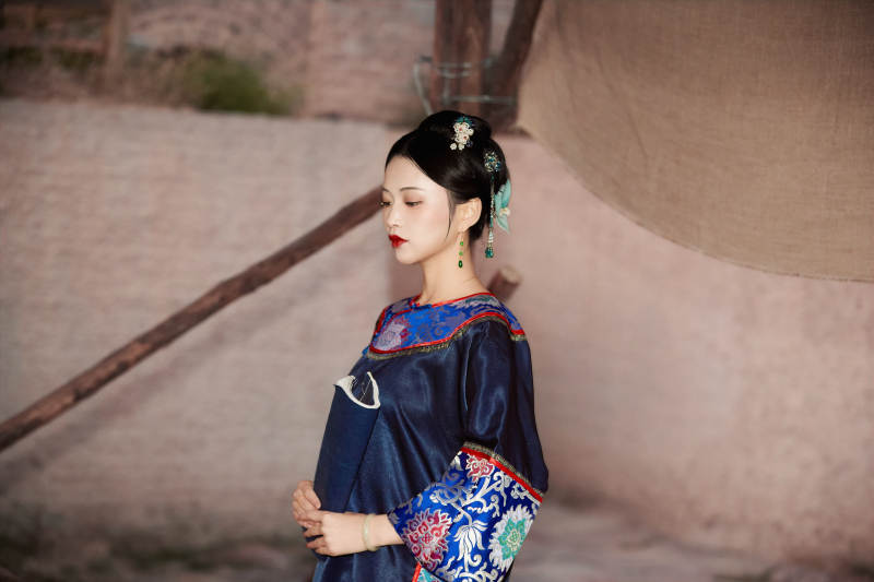 穿着中国晚清服饰在古城拍照的亚洲女性