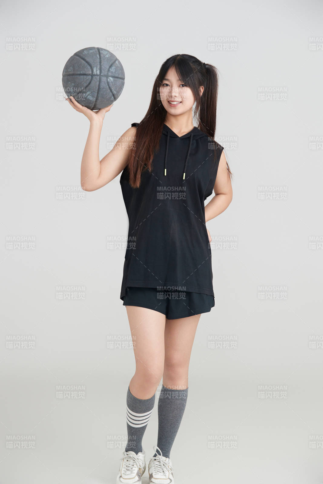 白色背景下的年轻女孩和篮球