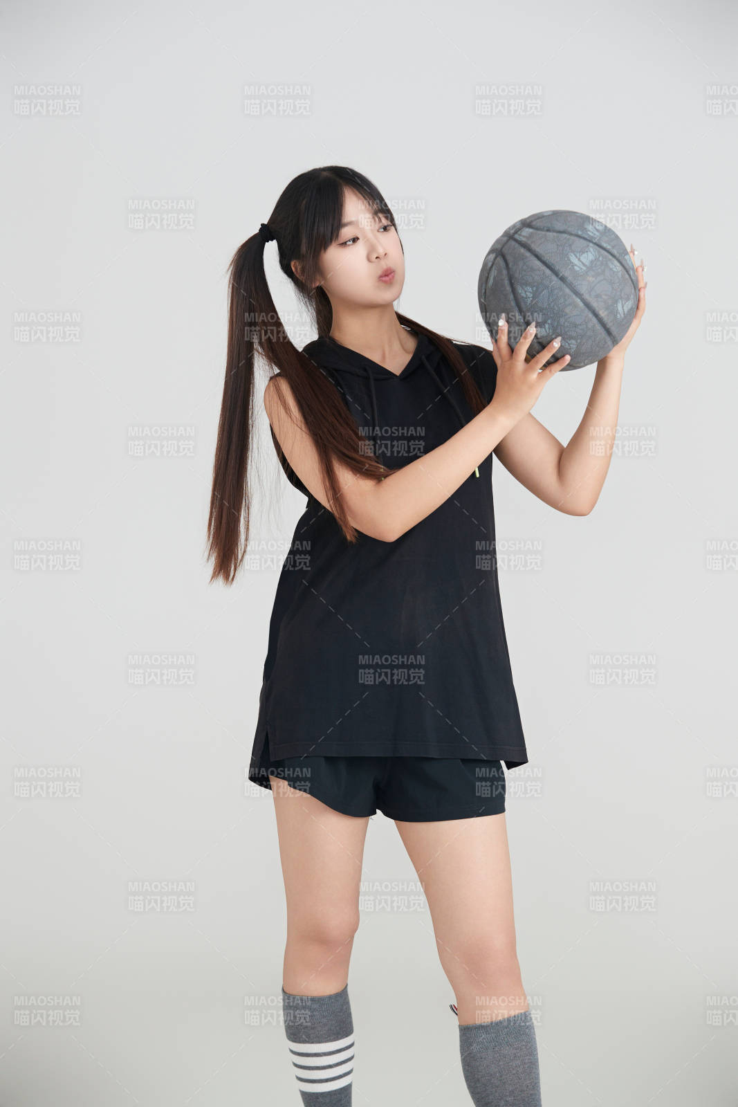 白色背景下的年轻女孩和篮球