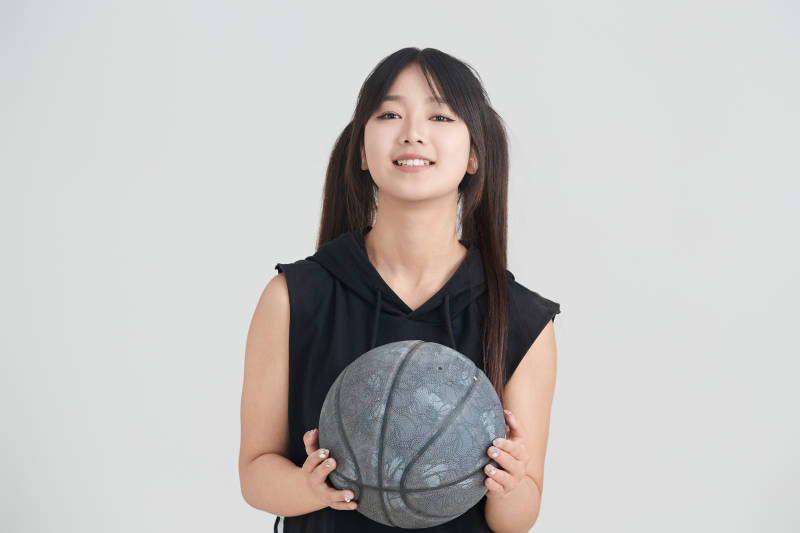 白色背景下的年轻女孩和篮球