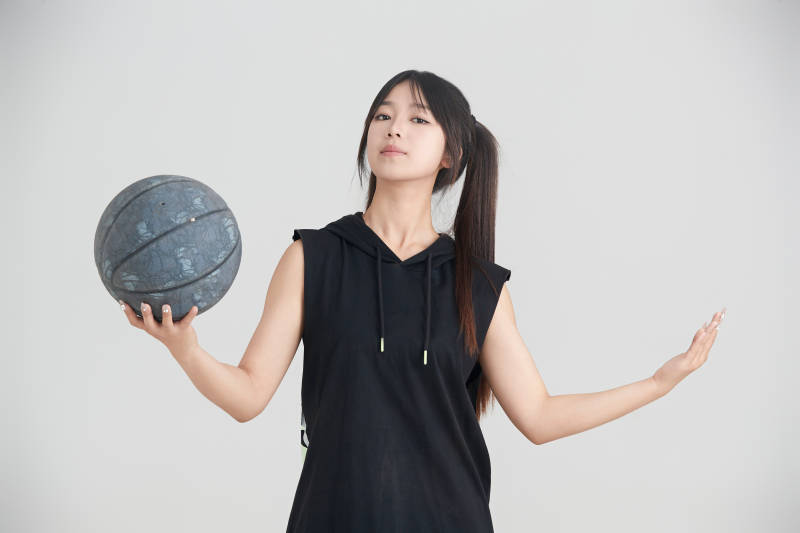 白色背景下的年轻女孩和篮球