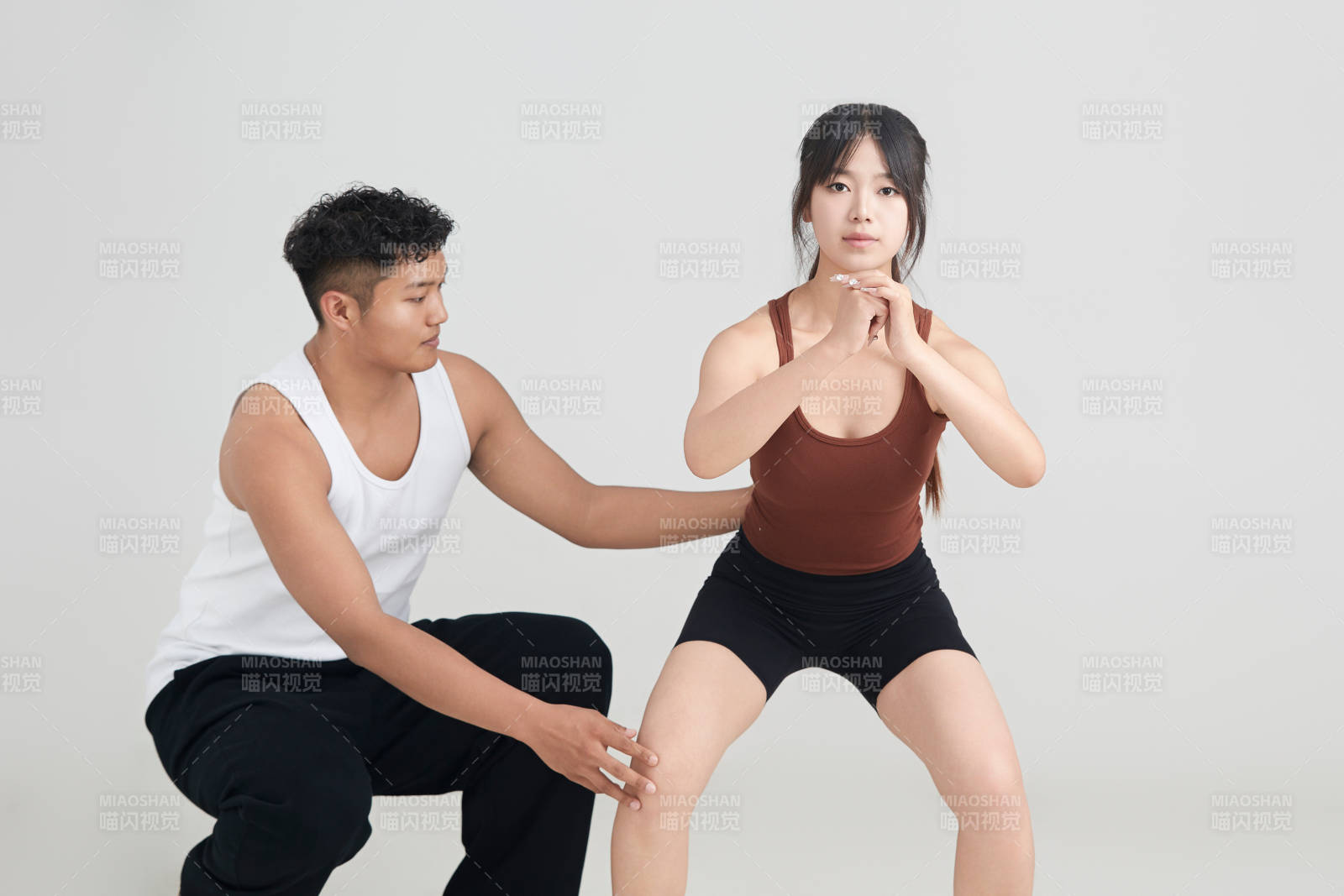 年輕女子在教練的指導下健身