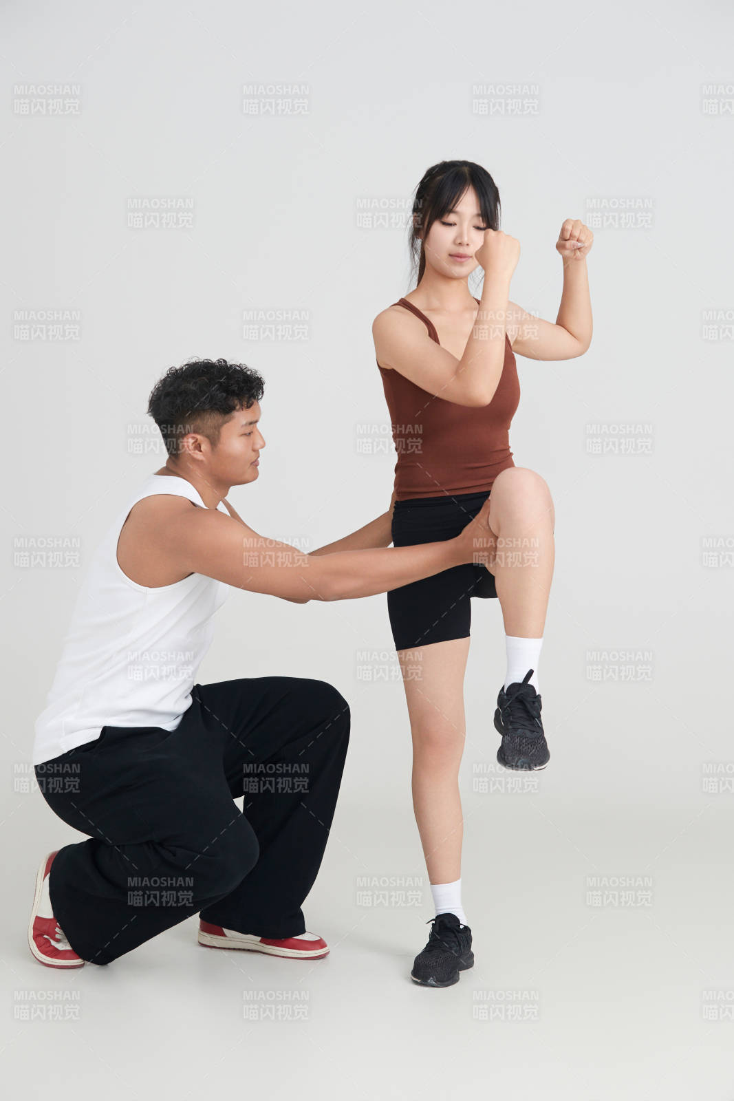 年輕女子在教練的指導下健身