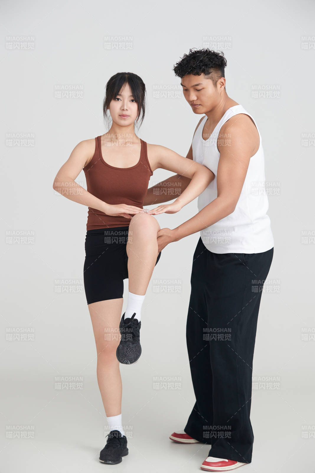 年輕女子在教練的指導下健身