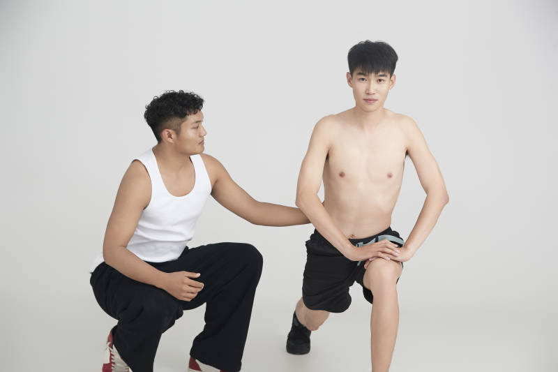 年轻男子在教练的指导下健身