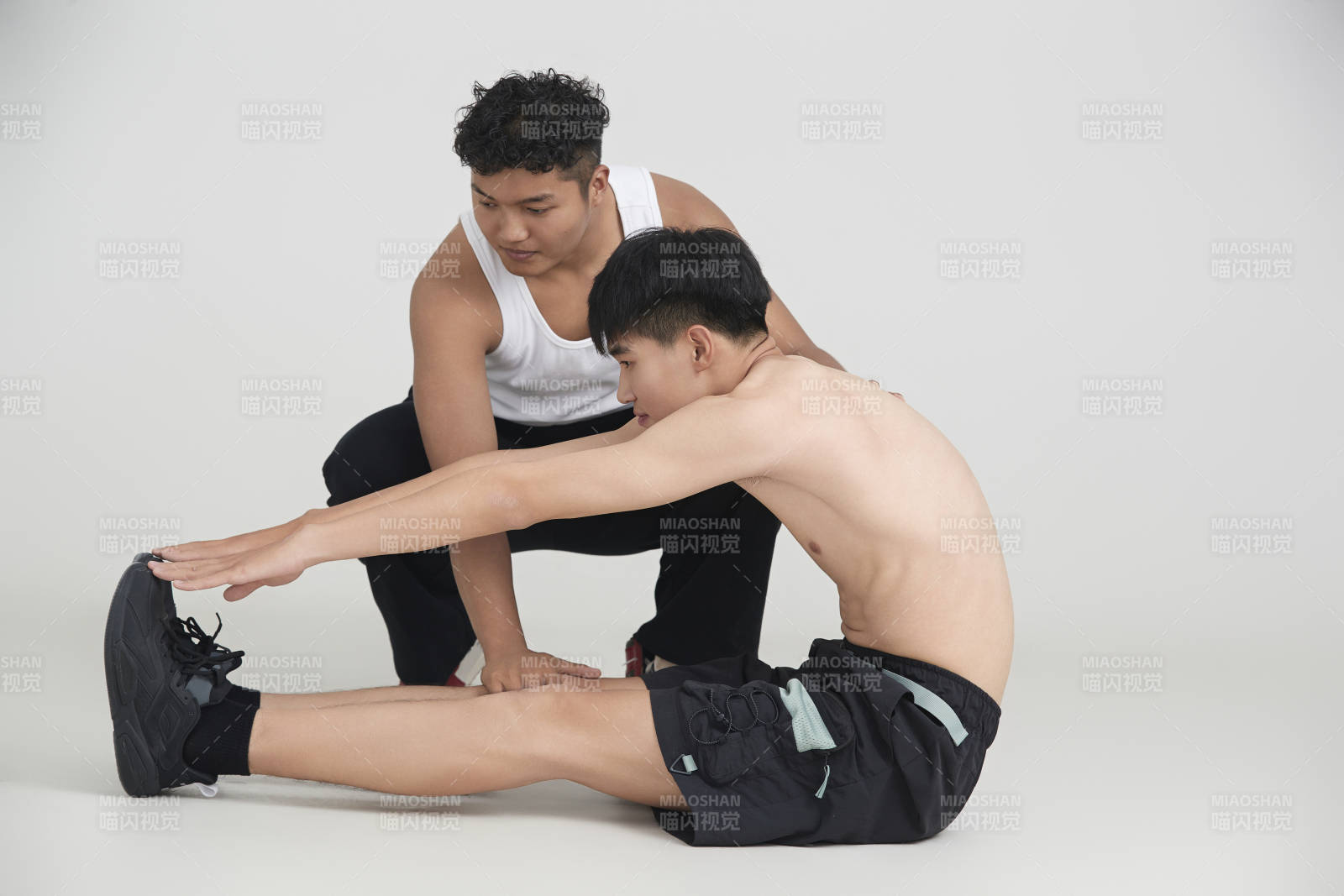 年輕男子在教練的指導下健身